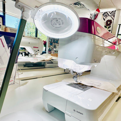 Sewing machine with a light on top in a workshop setting