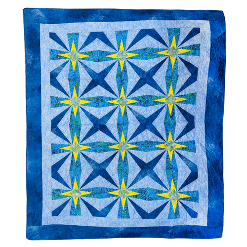 A square quilt with a geometric starburst pattern, featuring shades of blue, navy, and yellow on a white background with a blue border.